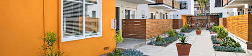 A modern house with a bright orange wall and a white wall with a window.