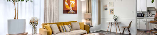 a living room with a yellow couch and a table