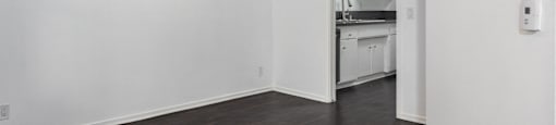 an empty living room with white walls and a ceiling fan