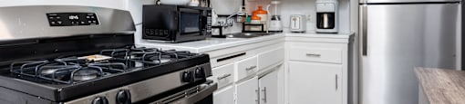 a kitchen with white cabinets and stainless steel appliances