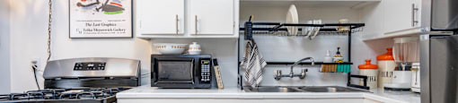 a kitchen with white cabinets and a stove and a sink