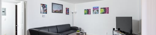 a living room with white walls and a black couch