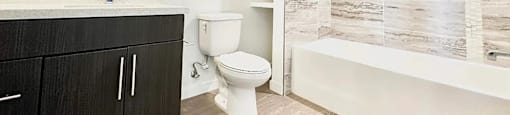 A bathroom with a toilet, sink, and a bathtub.