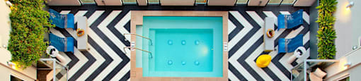 A black and white striped wall with a pool in the middle.