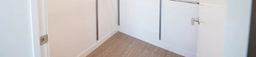 A walk-in closet with shelving and a white door.