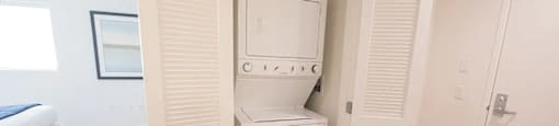 A white washing machine and dryer in a small room.