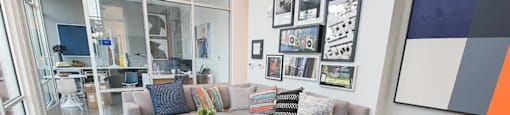 A living room with a grey couch and a blue rug.