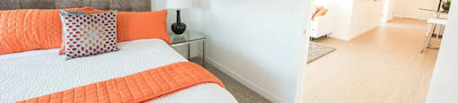 A bedroom with a bed, nightstand, and a painting on the wall.