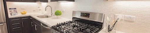 A modern kitchen with a stove top oven and microwave above it.