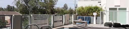 A pool in a residential area with a warning sign.