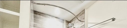 A bathroom with a white tub and a shower curtain with a wood pattern.