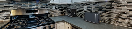 A modern kitchen with a stove, microwave, and toaster oven.