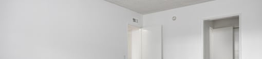 an empty living room with wood floors and white walls
