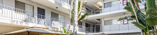 a courtyard with lounge chairs and umbrellas
