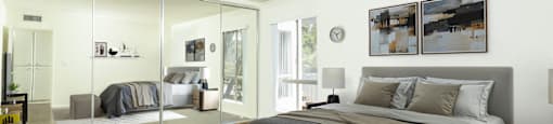 A bedroom with a large bed and a mirrored wall.