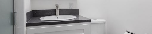 a white bathroom with a sink and a toilet