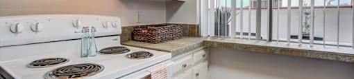 a kitchen with a stove top oven next to a window