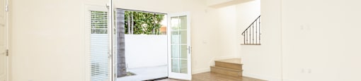 a living room with white walls and a sliding glass door