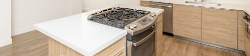 a kitchen with white counter tops and a stove top oven