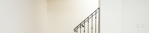 a staircase in a home with white walls and wooden stairs