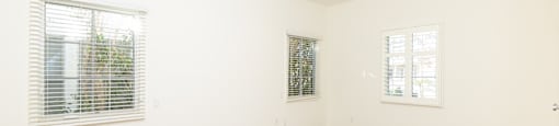 an empty living room with white walls and wood floors