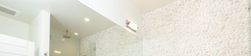 a large white bathroom with a sink and a mirror