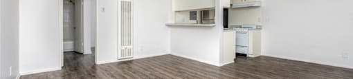 an empty living room with white walls and wood flooring