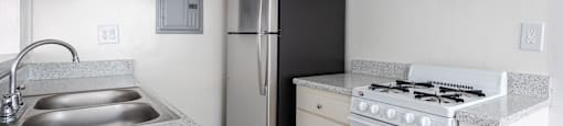 an empty kitchen with a stove refrigerator and sink