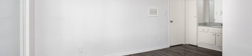 an empty living room with white walls and wood flooring