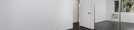 an empty living room with white walls and a sliding glass door