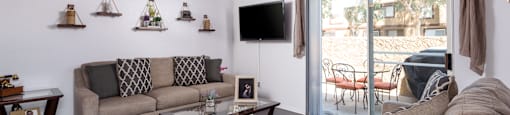 a living room with couches and a coffee table and a tv