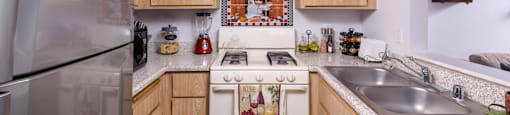 a kitchen with white appliances and wooden cabinets