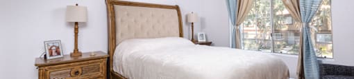 a bedroom with a bed and a dresser and a window