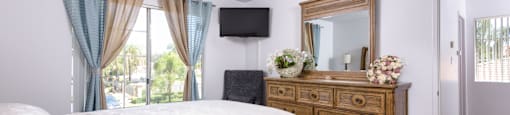 a bedroom with a bed and a dresser and a window