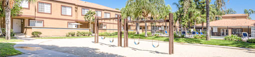 a playground in front of a building with palm trees