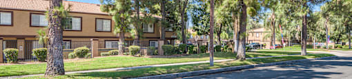 a street in front of an apartment building with trees