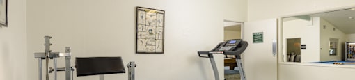 a gym with a treadmill and exercise equipment in a room