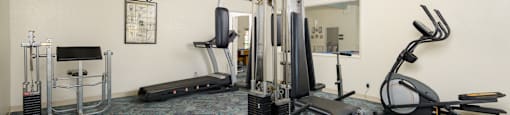 a gym with exercise equipment and a blue ball on the floor