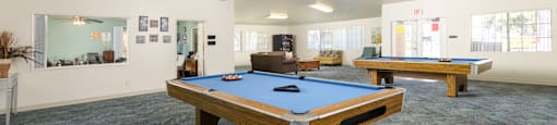 two pool tables in a community room with other amenities