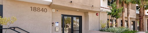 the entrance to a building with a glass door and stairs