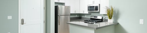 a kitchen with white cabinets and a stainless steel refrigerator
