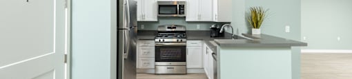 a kitchen with white cabinets and stainless steel appliances
