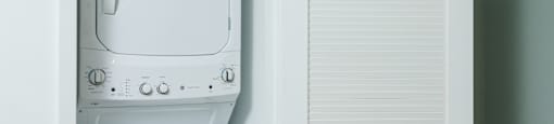 a white washer and dryer in a closet next to a door