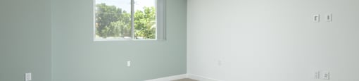 an empty room with white walls and a window
