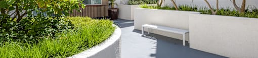 a courtyard with a bench and plants in front of a building