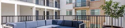 a communal area with couches and a coffee table in front of apartments