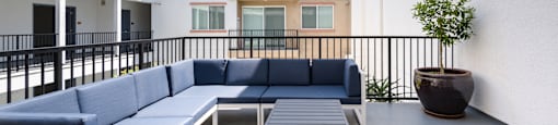 a lounge area with blue couches and a wooden table