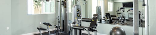 a gym with exercise equipment and weights in a building