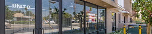 the entrance to a building with glass doors and a sidewalk