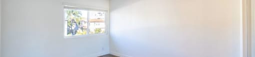 A room with wooden flooring and a window.